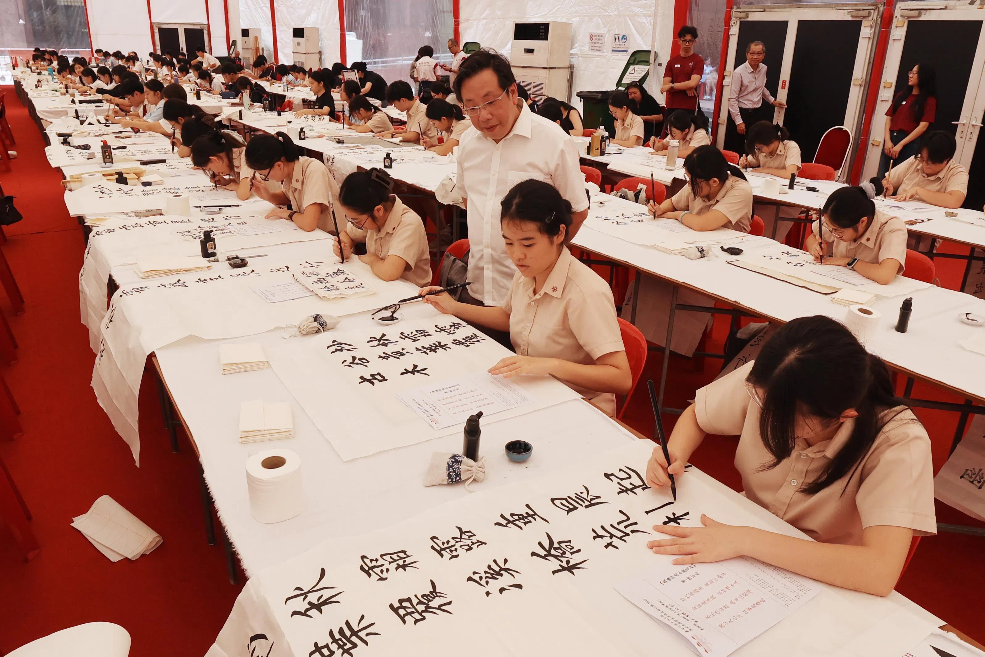 义安公司文化小组委员会主任张伟伟（白衣站立者）在现场观赛。（邬福梁摄）