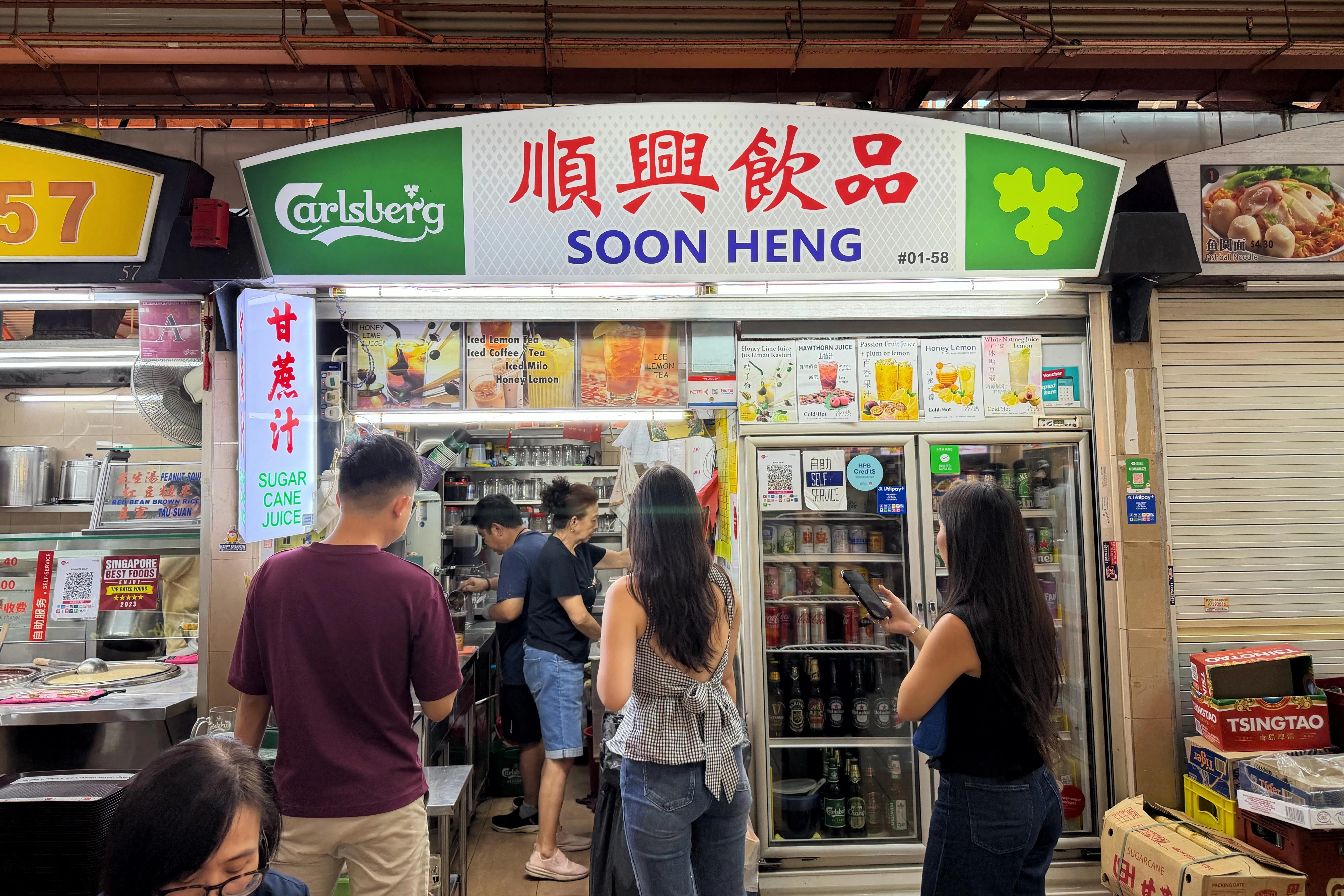 如今，他已能独立完成大部分工作，包括冲泡饮料、端送饮料和倒垃圾，就连当初不敢再碰的榨甘蔗机，现在也能重新操作。（黄宇璇摄）