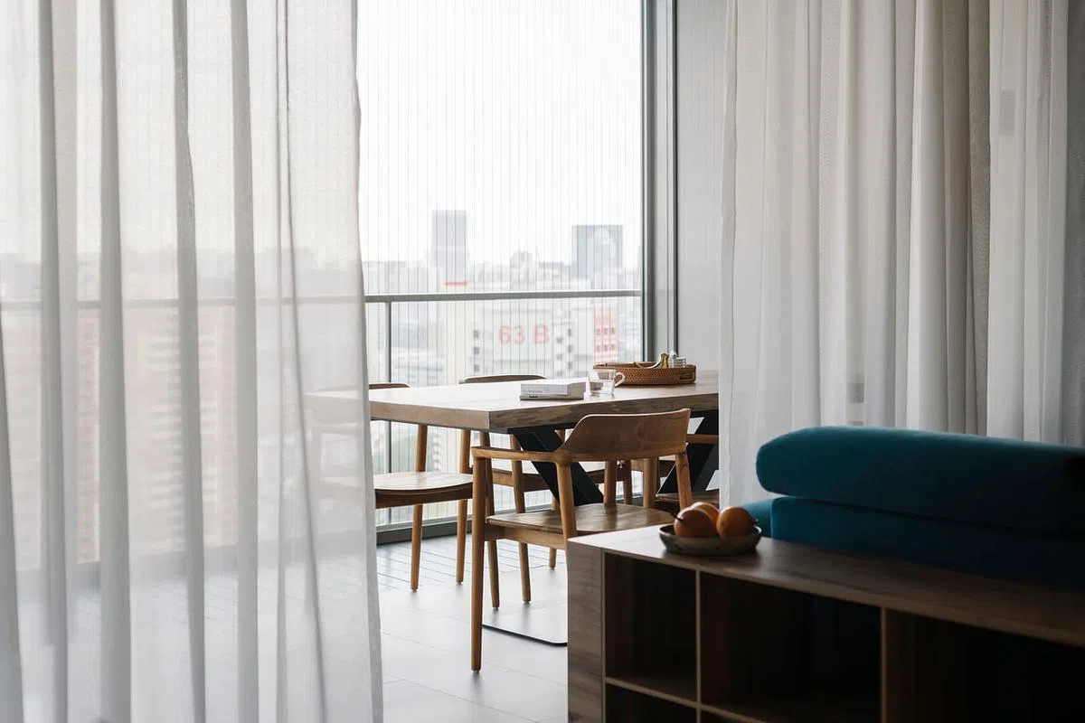 拨开半透明白窗帘，偌大的阳台足够让好客的主人放置多一张六人餐桌。（Metre Architects提供照片）