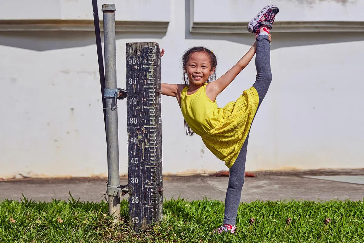 黄乐恩（7岁）身高1.1米，只稍微比一旁的洪水位计高出一些。（图/新报业媒体）