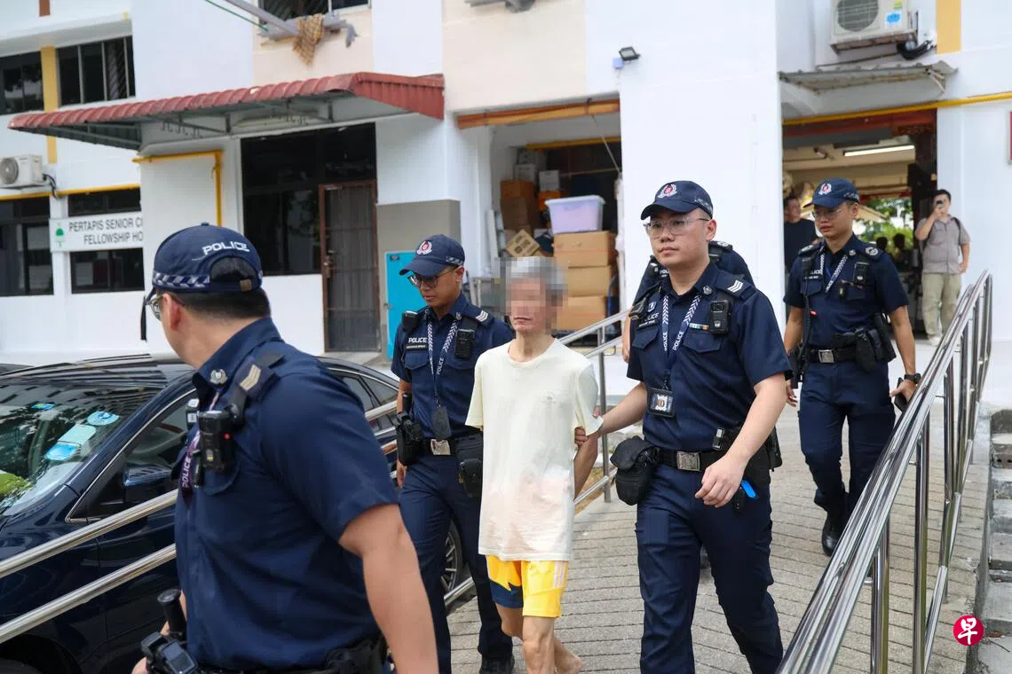 53岁男子星期二下午反锁屋内两个多小时后，被执法人员入屋逮捕，押上警车带走。 （陈斌勤摄）
