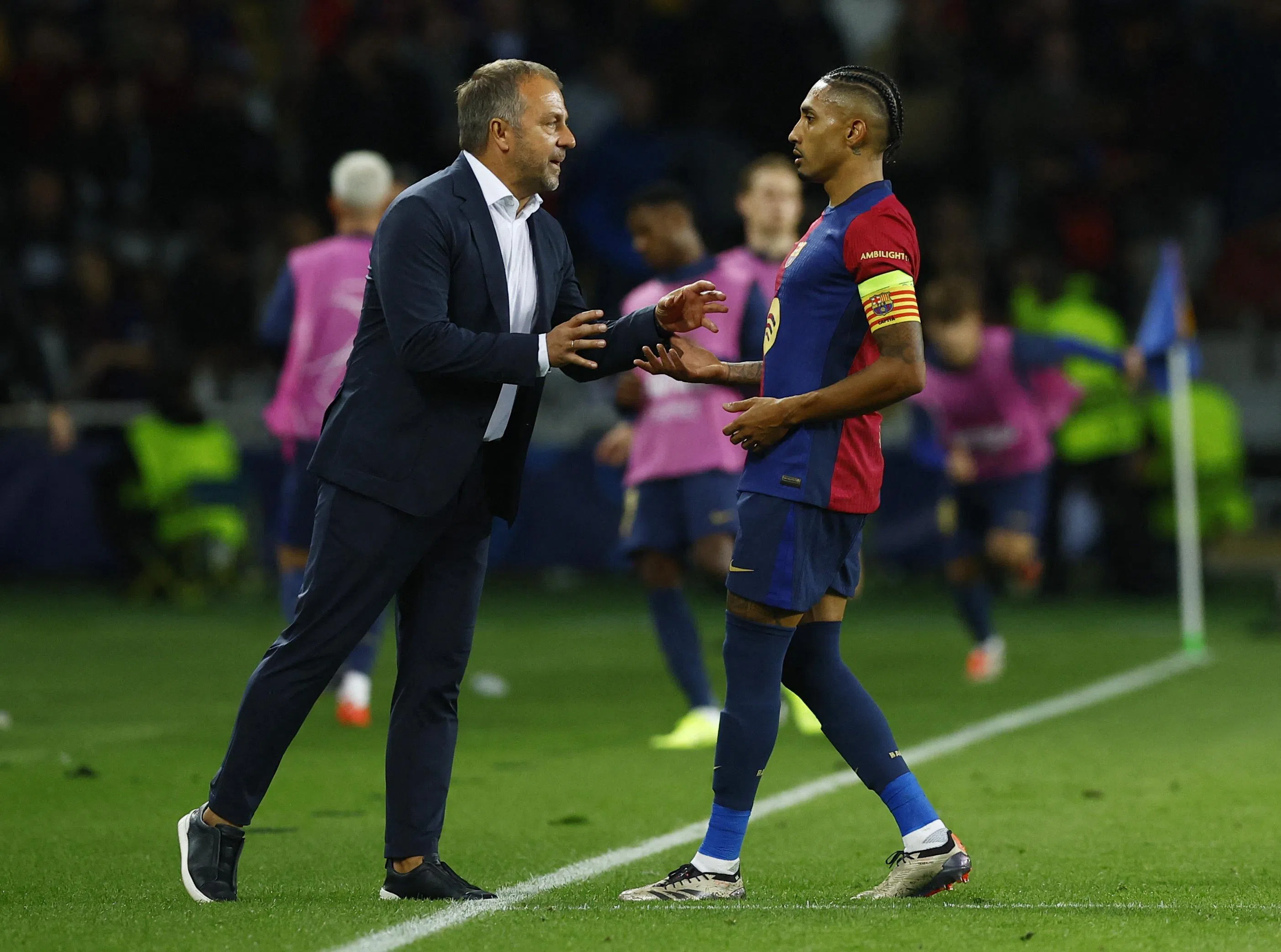 弗里克（左）在场边指导拉菲尼亚。（路透社）