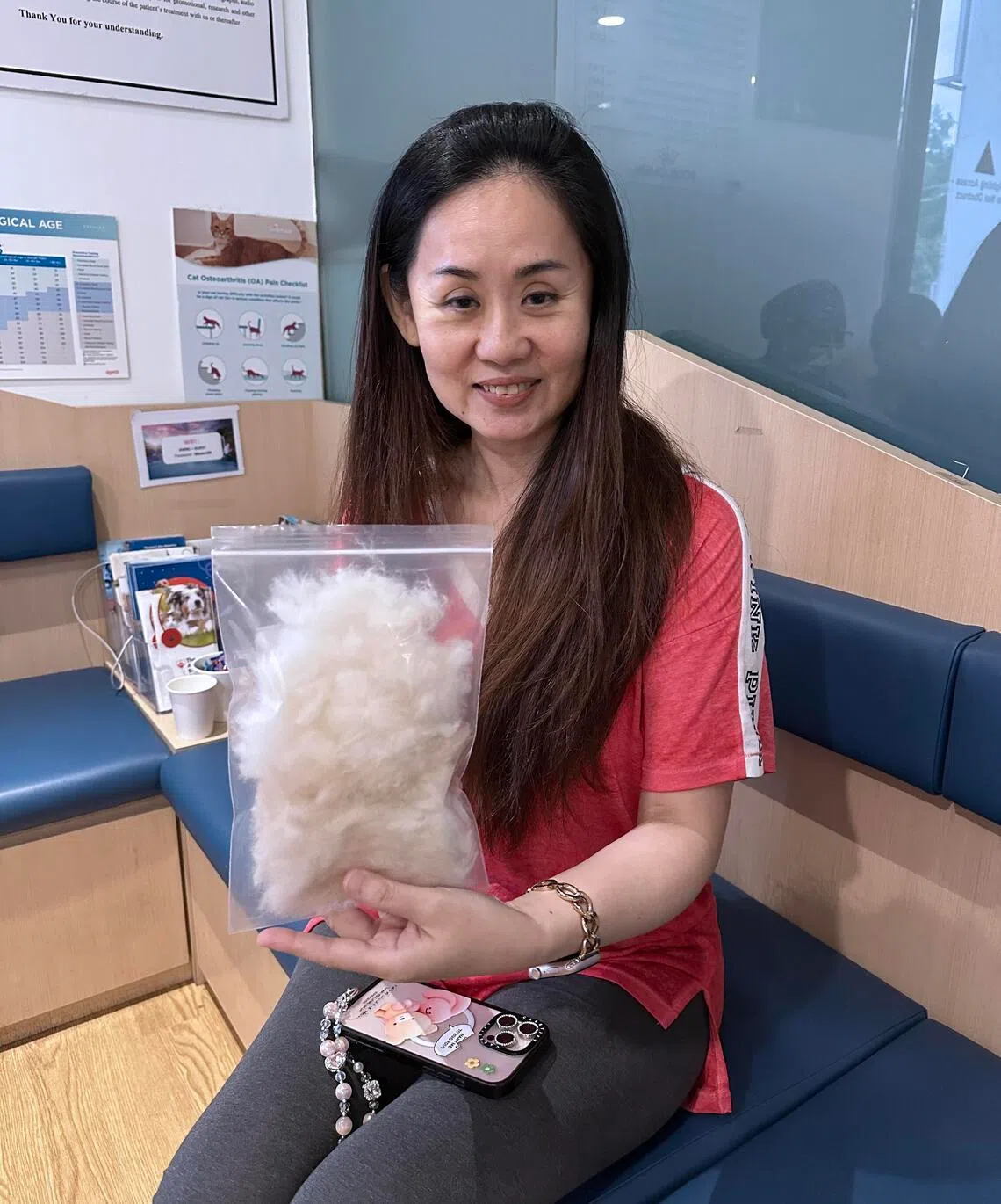 手术进行当天，莫壮仪难免忐忑不安，当护士把剃下的爱犬毛发交给在手术室外等候的她时，她又心疼又感动。（苏秉苓摄）
