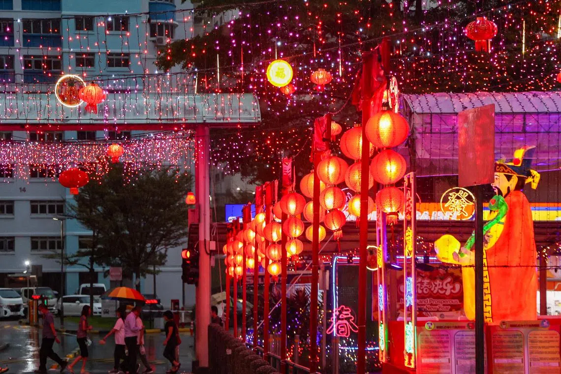 ABC砖厂巴刹与熟食中心一带张灯结彩，映衬着连日阴雨中行人匆匆的身影。平日人见人爱的财神爷，在雨天也不免遭冷遇。（陈斌勤摄）