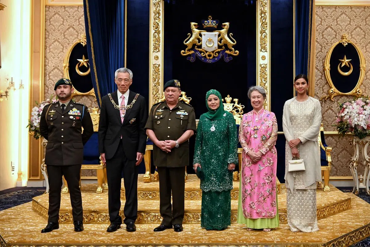 李显龙总理（左二）与夫人何晶（右二）获颁拿督勋章后，与柔佛苏丹依布拉欣（左三）、苏丹后拉惹查丽苏菲亚（右三）、柔佛王储东姑依斯迈（左一）和王储妃卡丽达布斯达曼合影。（海峡时报）