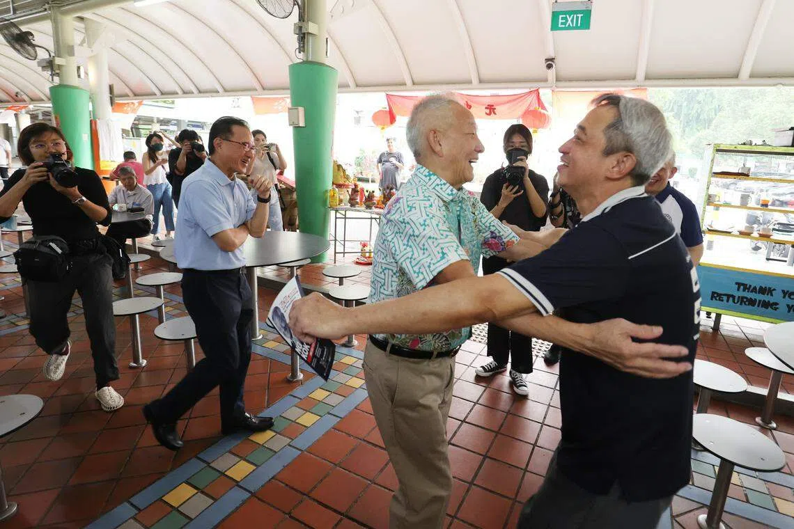 总统候选人黄国松（中）8月28日早上走访亚逸拉惹熟食中心时，与支持者拥抱，展现亲和力。（邝启聪摄）