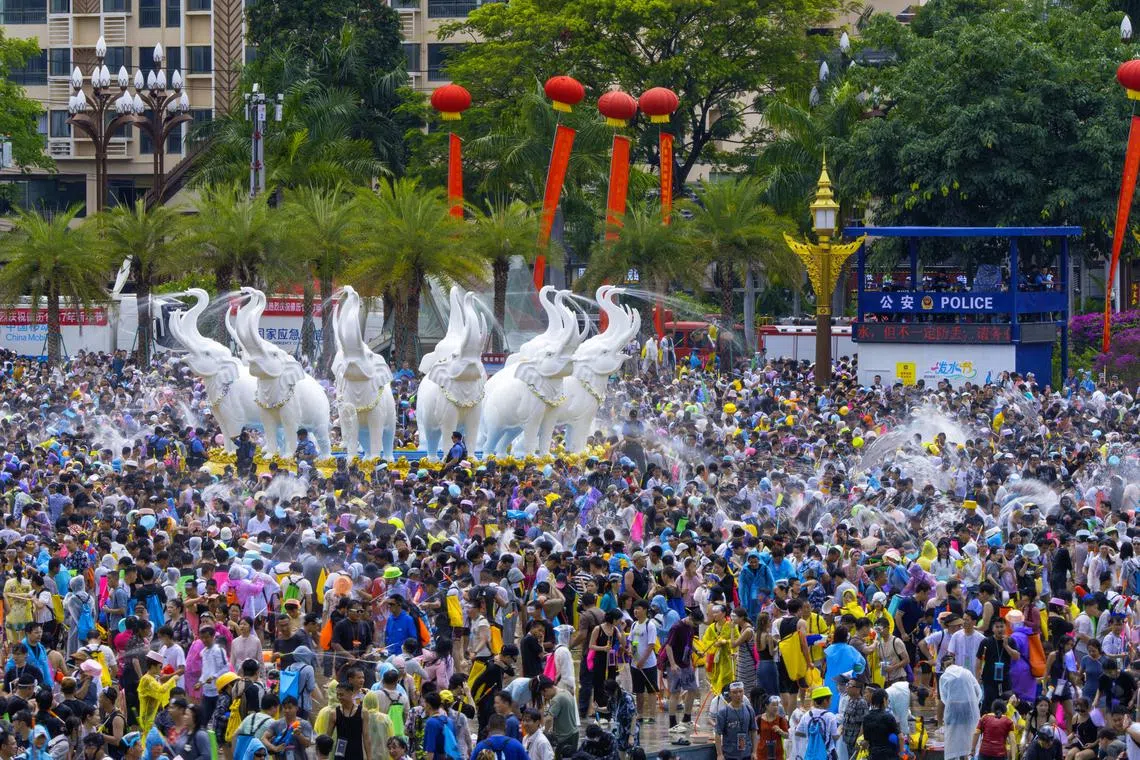 景洪市泼水广场中央，白玉象雕塑披着水光昂首向天，整片广场瞬间沸腾成欢乐的海洋。人们相信，每一滴掠过象牙的水珠，都会化作来年的五谷丰登。（蔡光发摄）