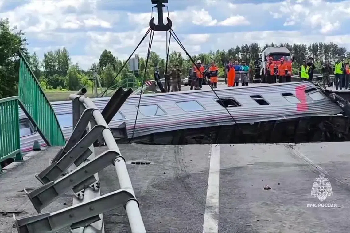 俄罗斯西南部与乌克兰接壤的布良斯克（Bryansk）地区一座公路高架桥5月31日晚坍塌，压向底下的火车轨道，导致一列开往莫斯科的客运列车脱轨。图为工作人员展开救援与善后处理工作。（法新社）