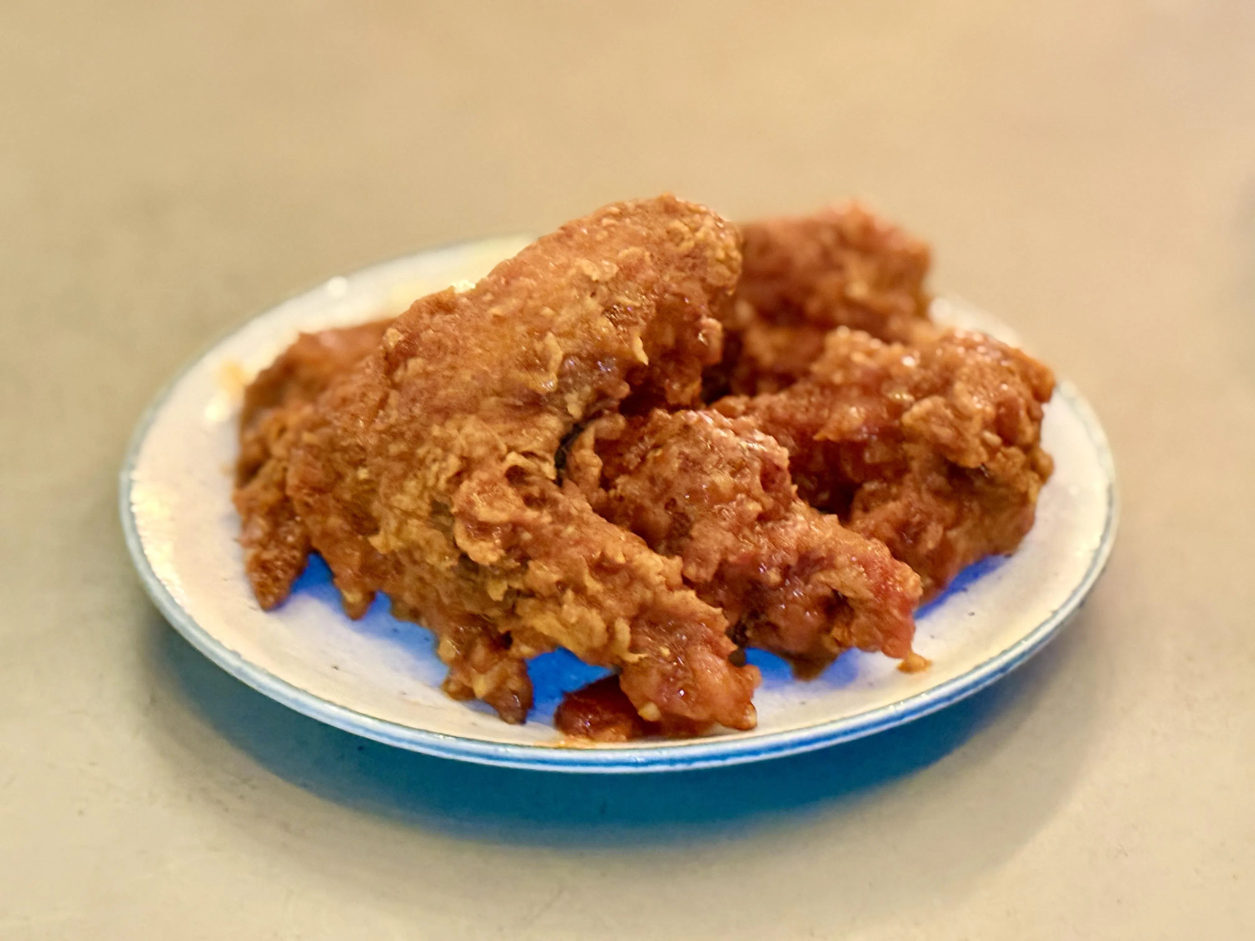 炸鸡翅外皮香脆，遇上特制韩式辣酱，热辣鲜香。（叶晓虹摄）