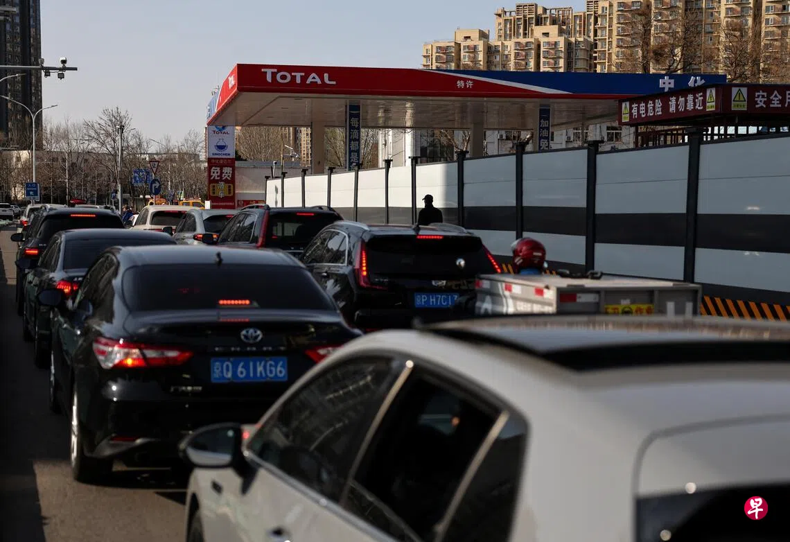 Image 7: 中国北京一家中化道达尔油站星期天（3月22日）排起车龙。 （路透社）