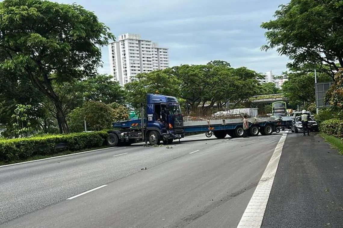 一辆平板拖车在泛岛快速公路（PIE）靠近勿洛的路段打滑，车身横跨三条车道，导致往机场方向的交通受阻。（取自网络）