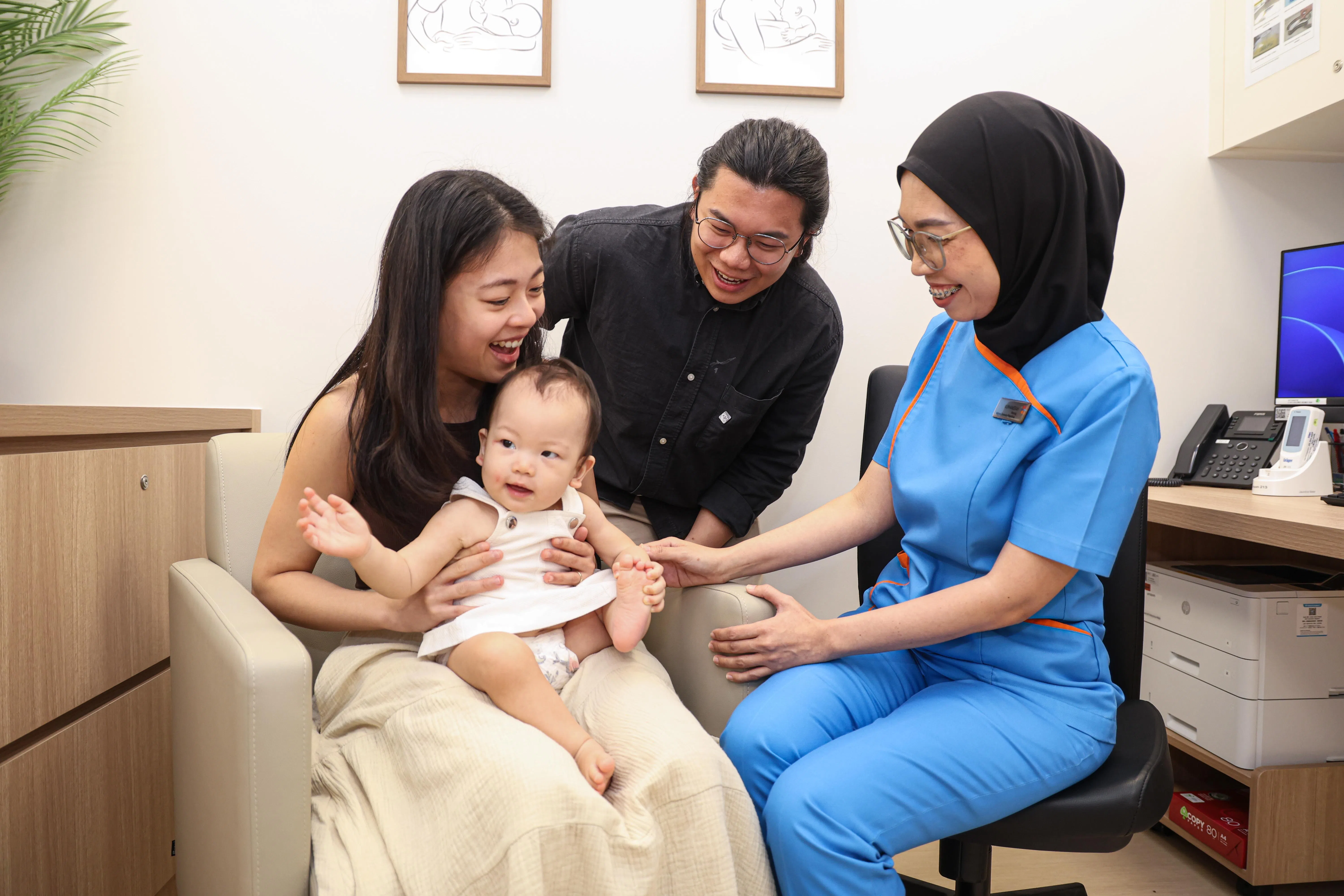 新手妈妈杨皎敏（左一）曾因哺乳困难，咨询哺乳顾问高级注册护士努哈妮莎（右一）。女儿吴恩希目前已近11个月大。右二为杨皎敏丈夫吴修锐。 （关俊威摄）