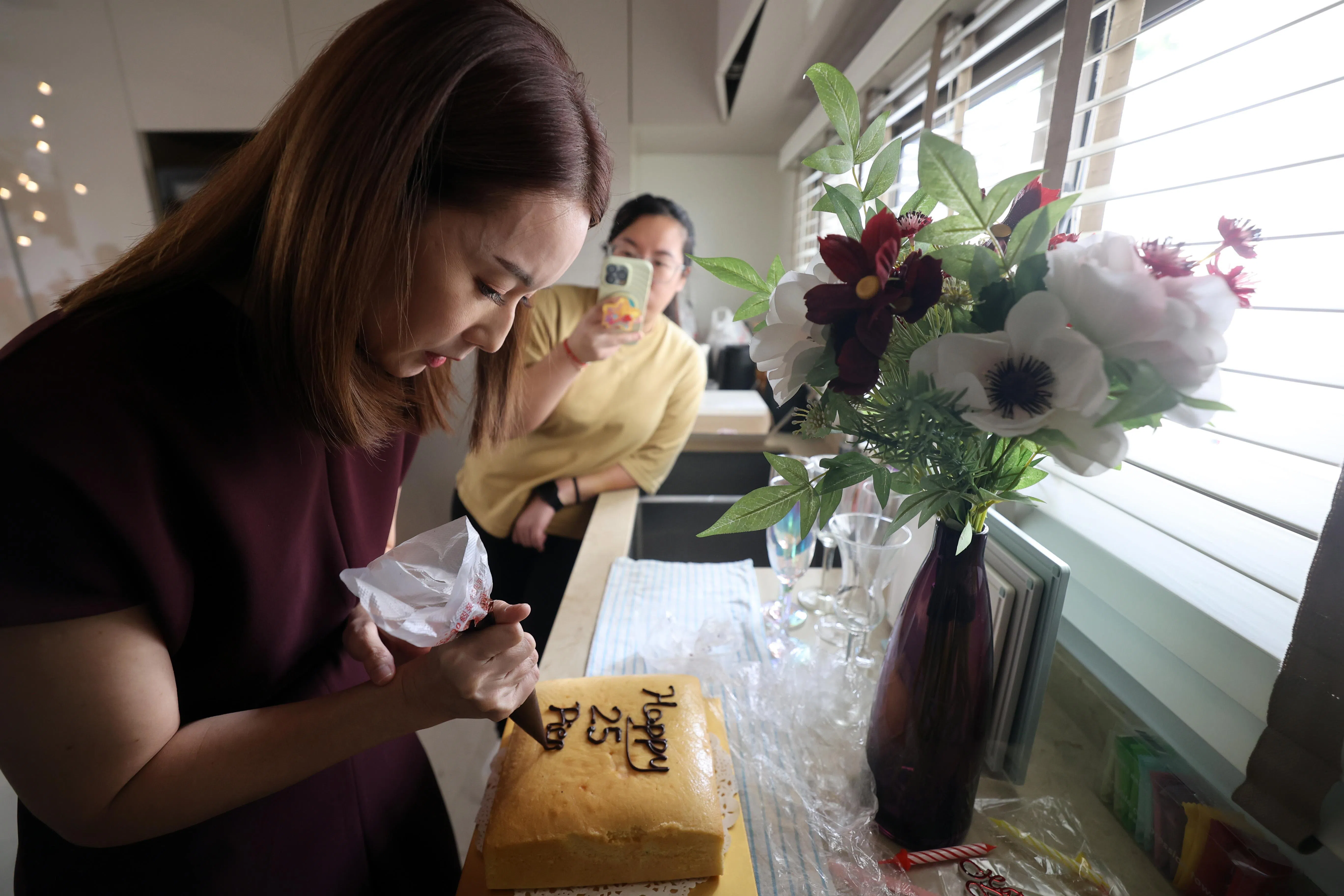 林湘萍为搭档方展发自制牛油蛋糕，在蛋糕上写“25岁生日快乐”。（邝启聪摄）