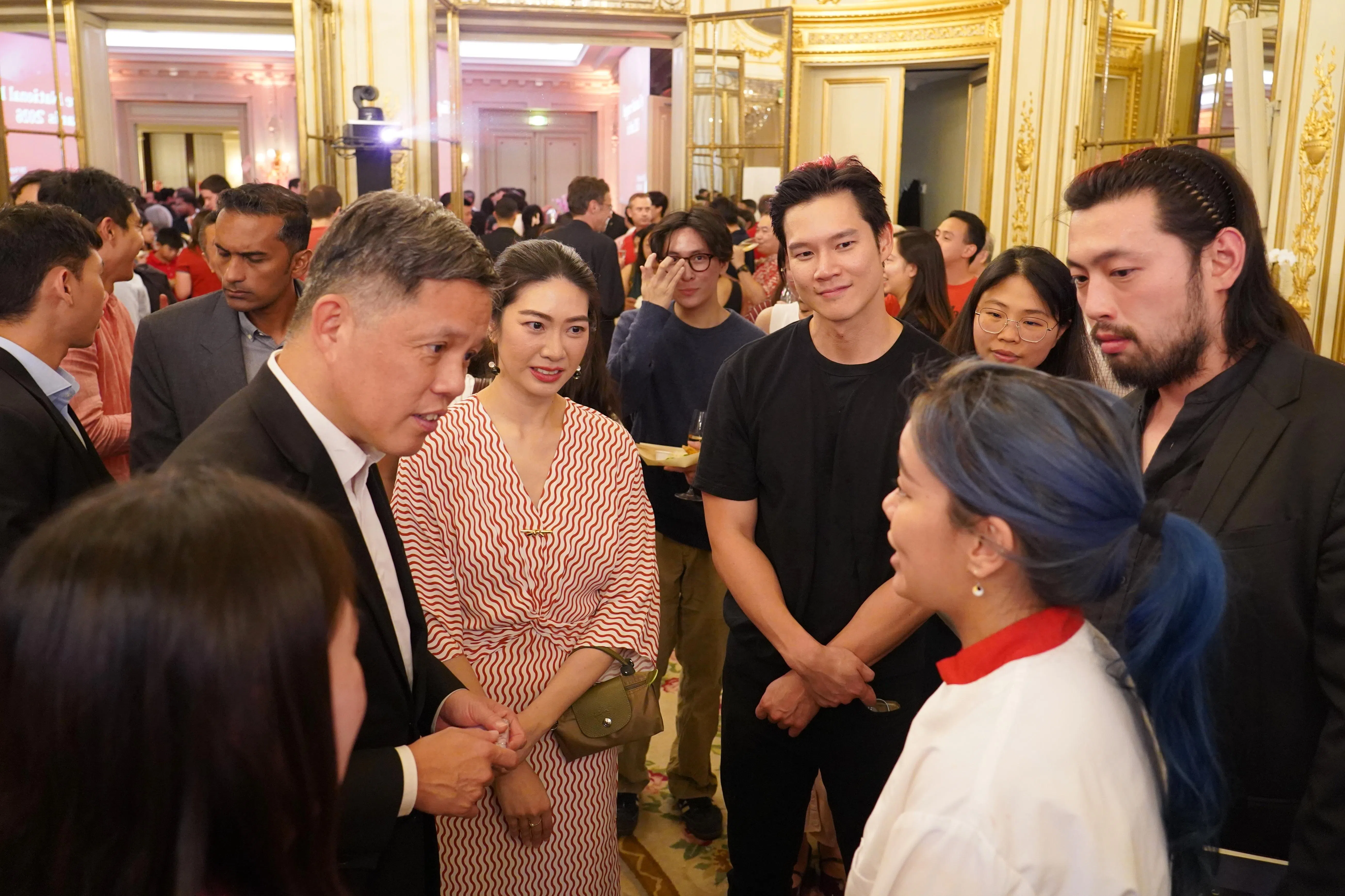 公共服务统筹部长兼国防部长陈振声（左一）出席在巴黎举行的新加坡国庆日招待会，与旅居法国的新加坡人交流。（国防部提供）