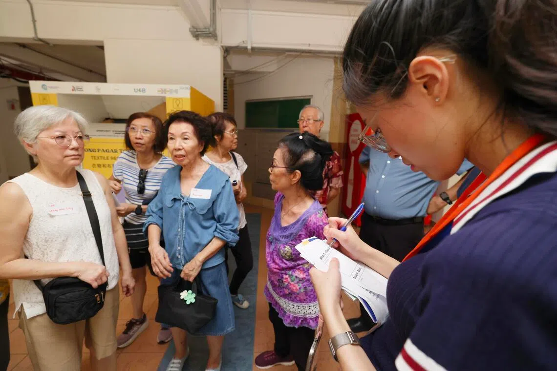 史波蒂斯兀园居民星期天（4月26日）分组到不同地点“考察”，讨论改善环境的方案。项目研究小组的代表（右一）也随行记录大家的意见和反馈。（郑一鸣摄）