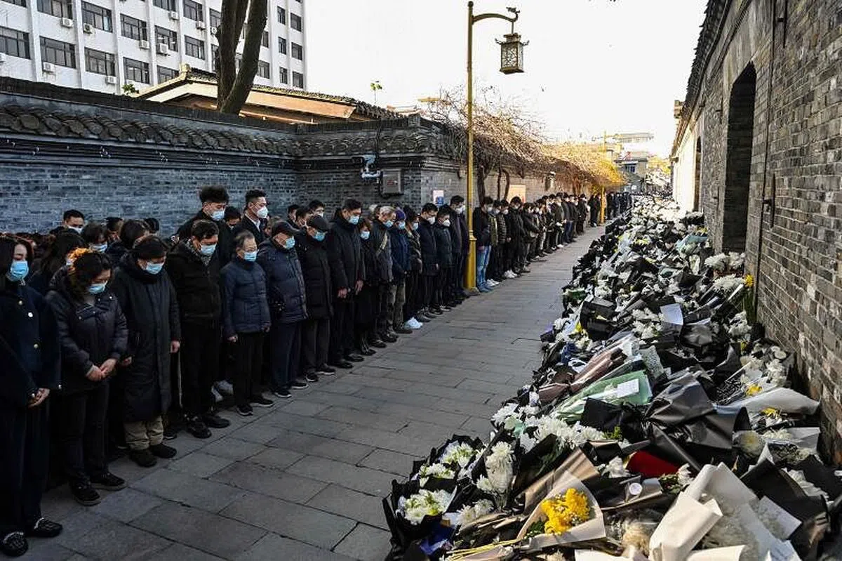 中国民众12月6日在位于江苏扬州的江泽民故居外献花默哀。（法新社）