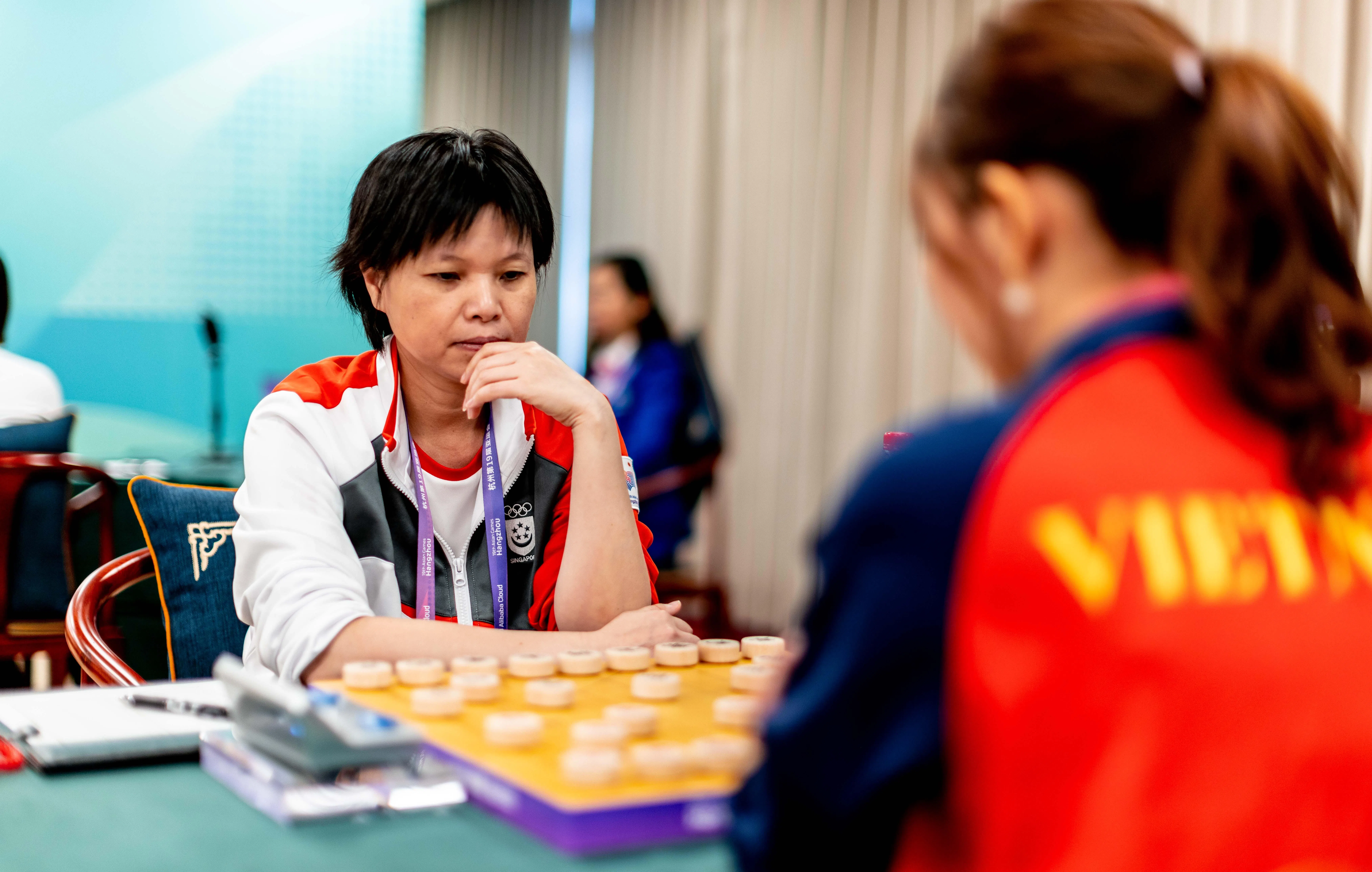 我国棋手吴兰香（左）战胜越南的阮氏菲廉。（新加坡全国奥理会提供）