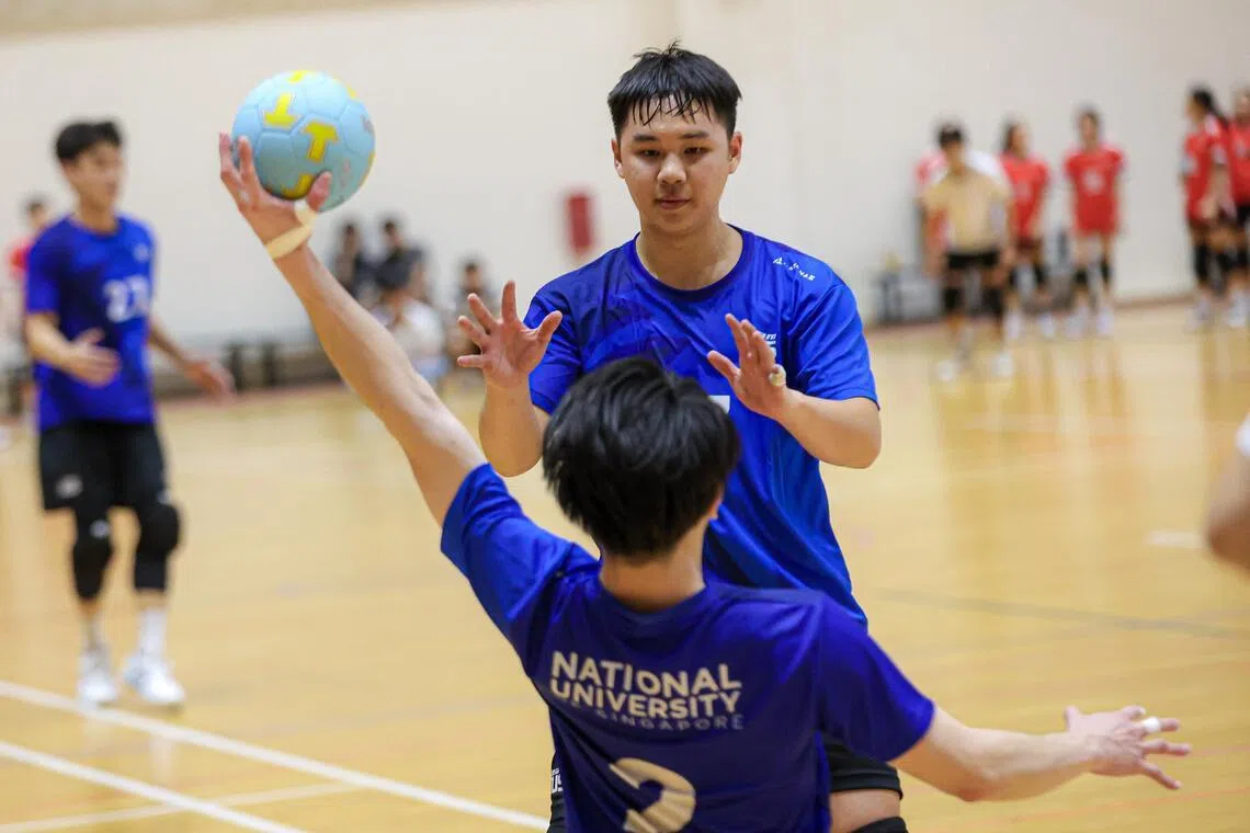 一名球员在队友接住对方射门后，举起手等着与他击掌。（游甯稀摄）