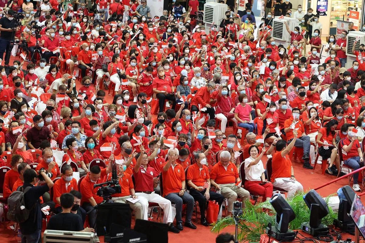 爱国歌曲大家唱活动在疫情后首次回归线下，上千名观众将现场装点成红色海洋，在一首首脍炙人口的国庆歌曲中为新加坡庆生。（唐家鸿摄）
