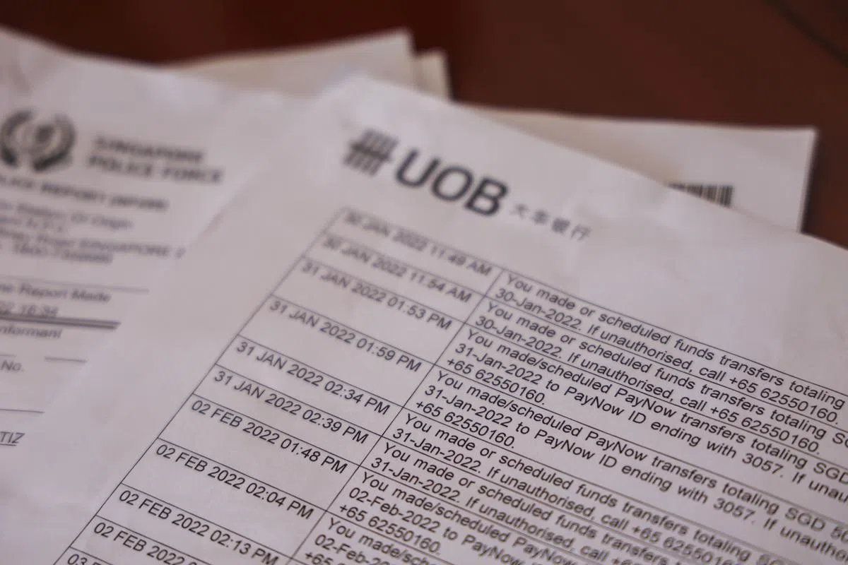 冯太太向记者出示报案记录，以及大华银行的转账记录。大华银行在账单中提醒，如果这笔转账未经户头持有人允许，应拨打热线通报。（白艳琳摄）