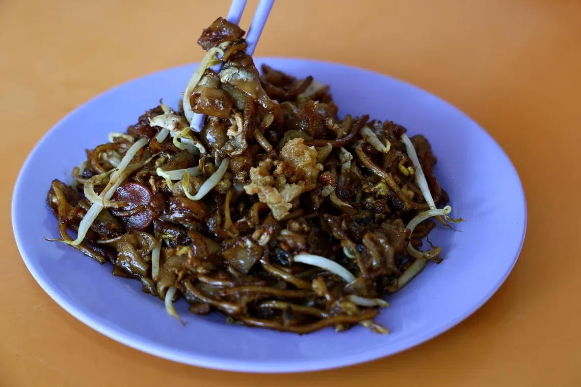 享用福发炒粿条时，加上猪油渣，更美味。（龙国雄摄）