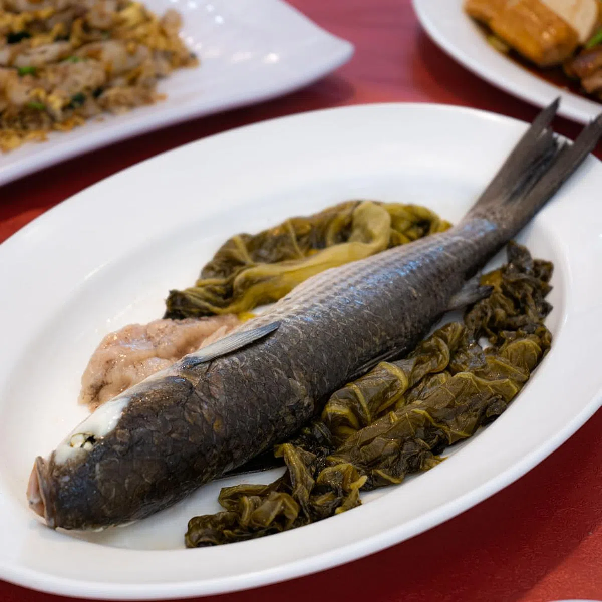 新潮园以酸菜包裹的蒸乌鱼。　