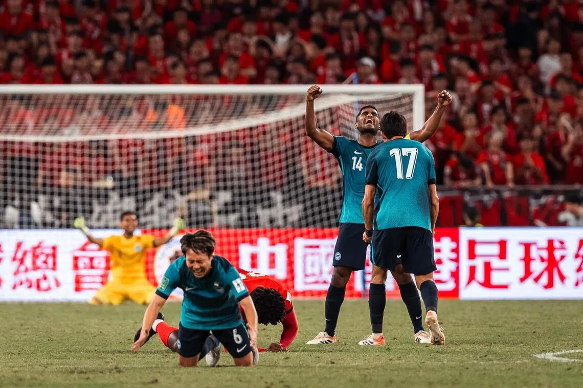 比赛结束的哨声响起后，雄狮队中场仲村京雅（前）和门将伊兹万（黄衣）跪地庆祝，队长哈里斯（14号）双手指握拳呐喊，难掩激动。（新加坡足球总会提供）