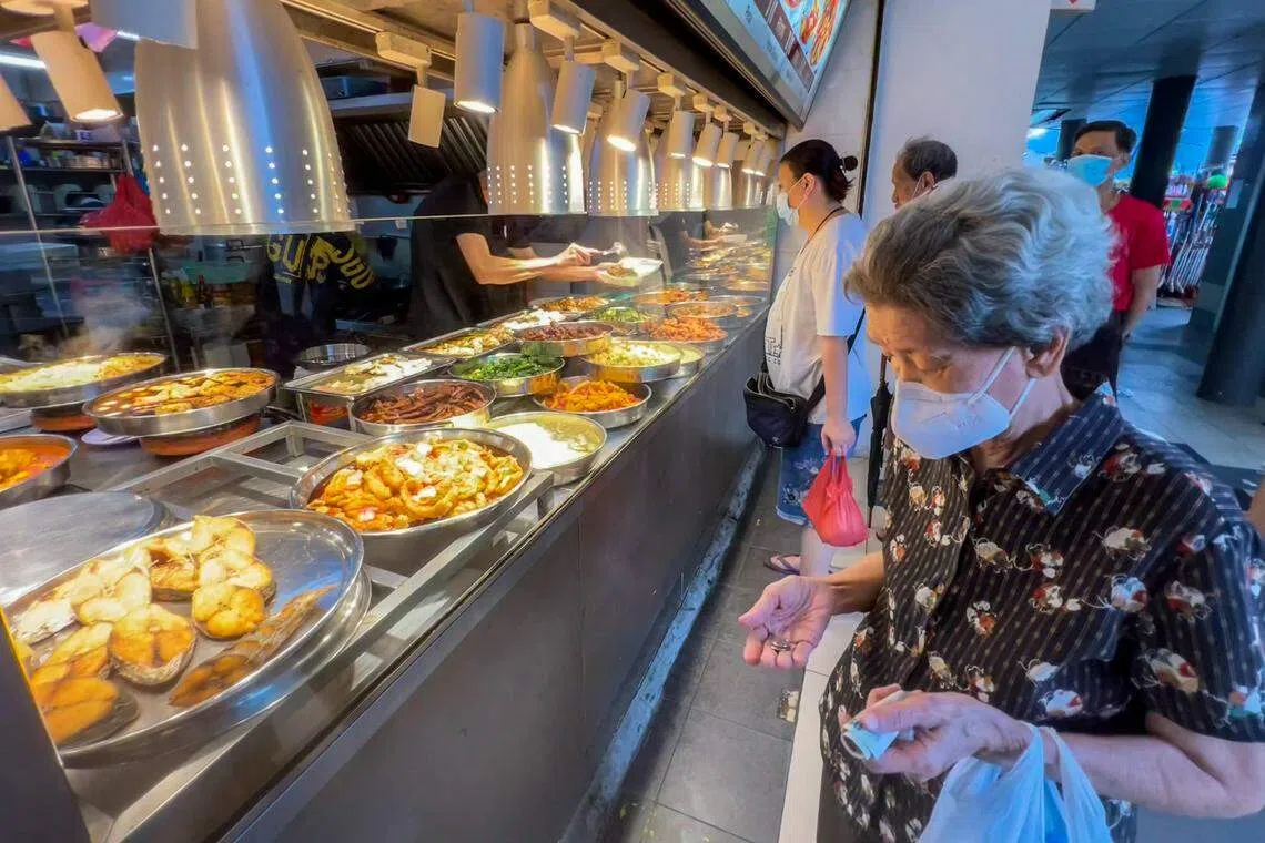 近年来新加坡感受到通货膨胀的压力，经济实惠的杂菜饭也难免起价。对于一般公众，杂菜饭仍是解决一日三餐的首选。冠病疫情期间，一名老妇在锦茂路第19座组屋楼下咖啡店打包杂菜饭。通胀所带来的冲击，普通老百姓总是首当其冲。如何帮助低收入与弱势群体应对更高的物价，需要国家和社会的合作。（陈斌勤摄）