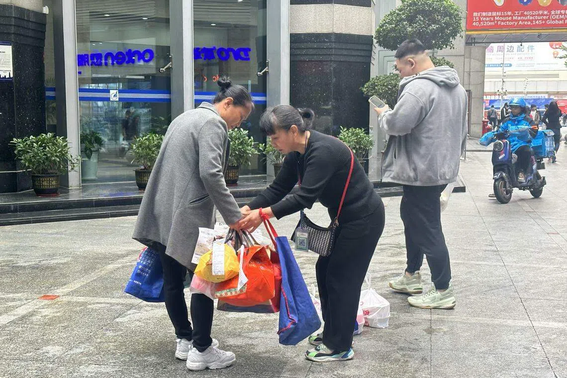 代送阿姨私下交换订单，集中相近楼层的外卖，让派送工作更高效。（林煇智摄）