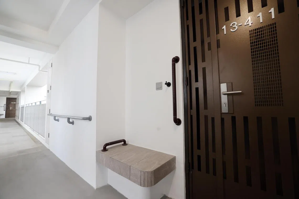 每户社区关爱组屋外都砌了一张水泥椅及安装了一个挂钩，方便年长者使用。（邝启聪摄）