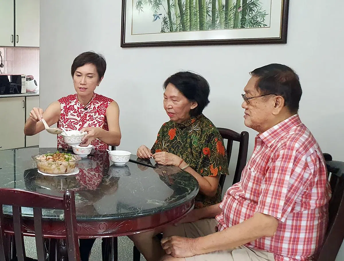 通讯及新闻部长兼内政部第二部长杨莉明（左起）在母亲节来临之际，为母亲廖菊秋和父亲杨启发烹煮传统客家算盘子。（通讯及新闻部提供）