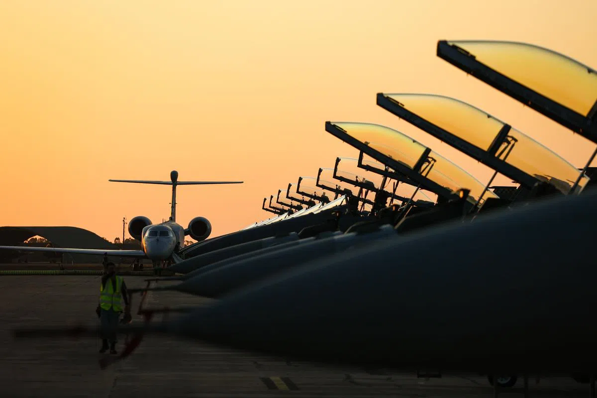 我国空军派遣的F-15SG战机和湾流（ Gulfstream）550型空中预警机（左一） 停放在澳洲的达尔文空军基地。（李健玮摄）