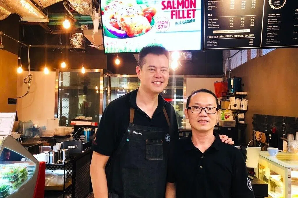 傅孙明与前监狱官罗元寿在丹戎巴葛地铁站的首家The Caffeine Experience咖啡馆。（受访者提供）