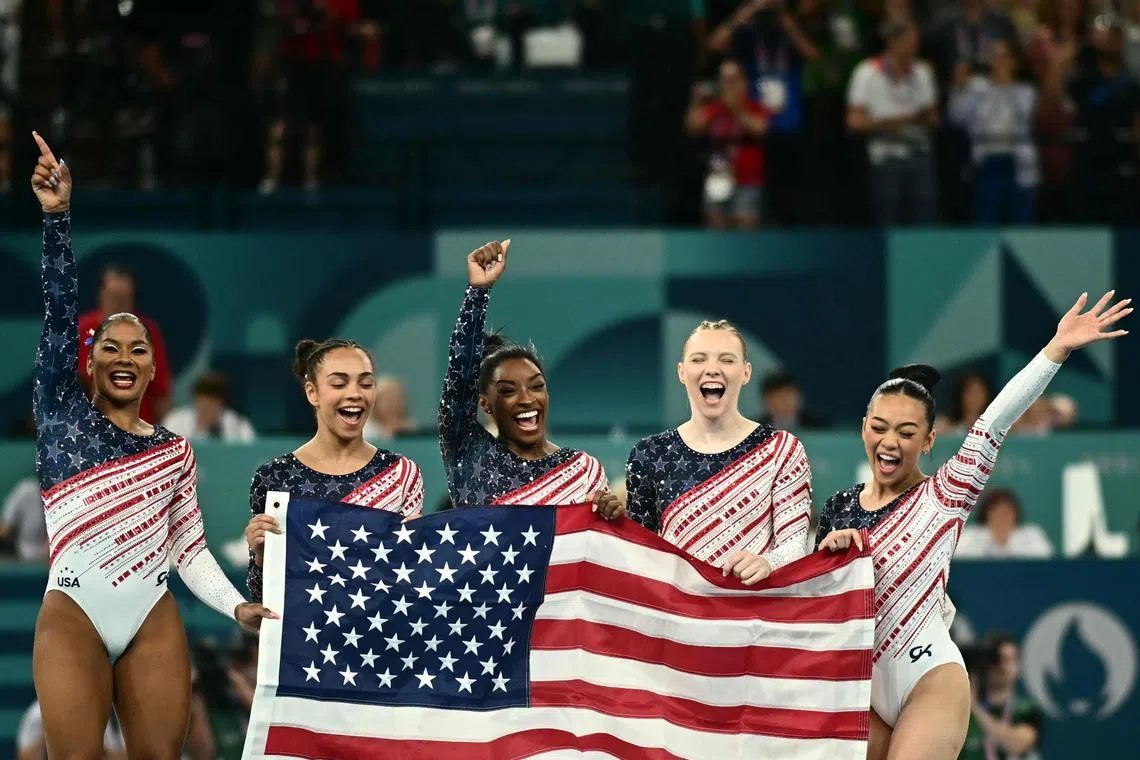 西蒙妮（中）和队友们帮助美国第四次夺得竞技体操女子团体冠军。（法新社）