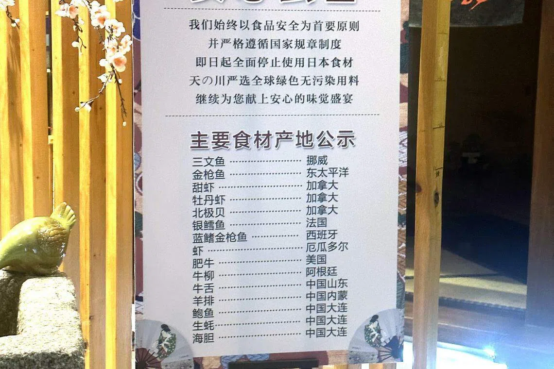 大连开发区一家日料店在店门口摆放公告，指餐馆已停止使用从日本进口的海产品，并列出所有食材的产地，让食客放心。（林煇智摄）