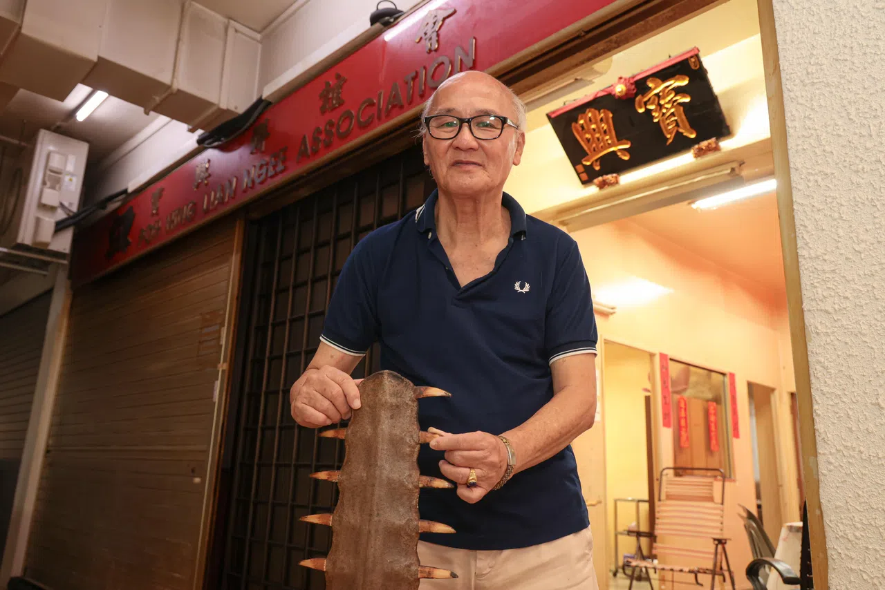 73岁的林平仲是宝兴联谊会的第三代会员，展示当时从事驳船业的“镇间之宝”鲨鱼剑。（李冠卫摄）