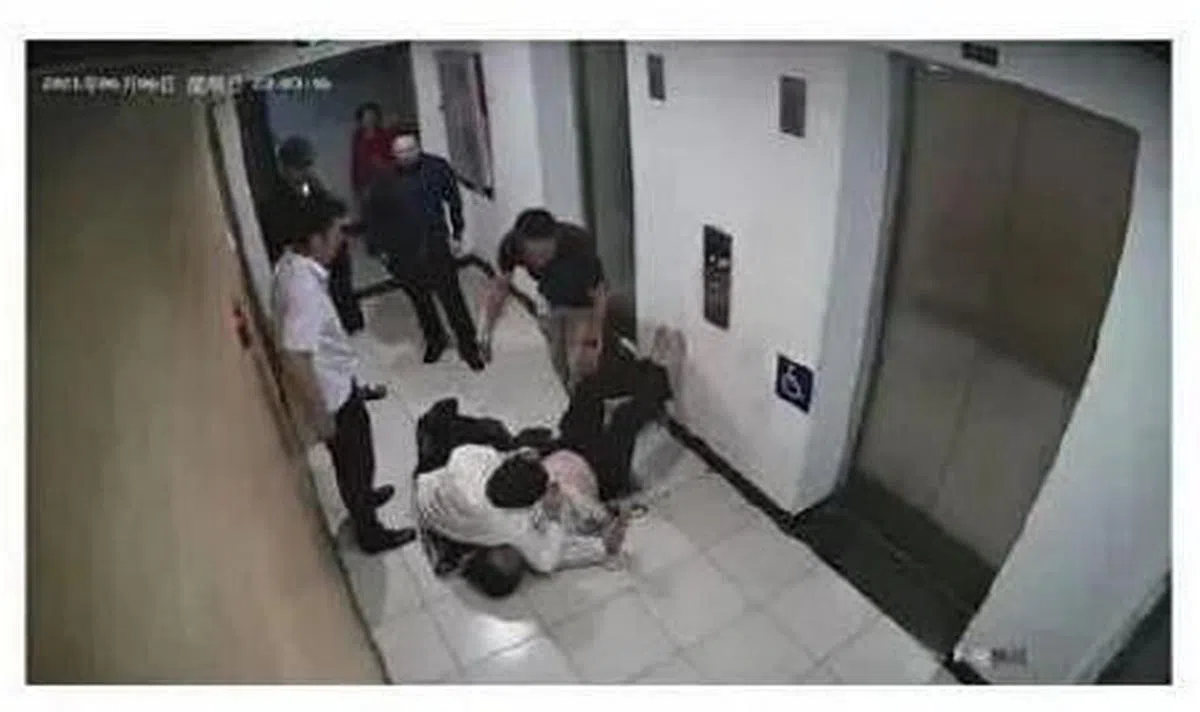 张陶殴打两名院士的监控视频截图显示，张陶将倒地的王晋年锁喉。（《中国新闻周刊》）