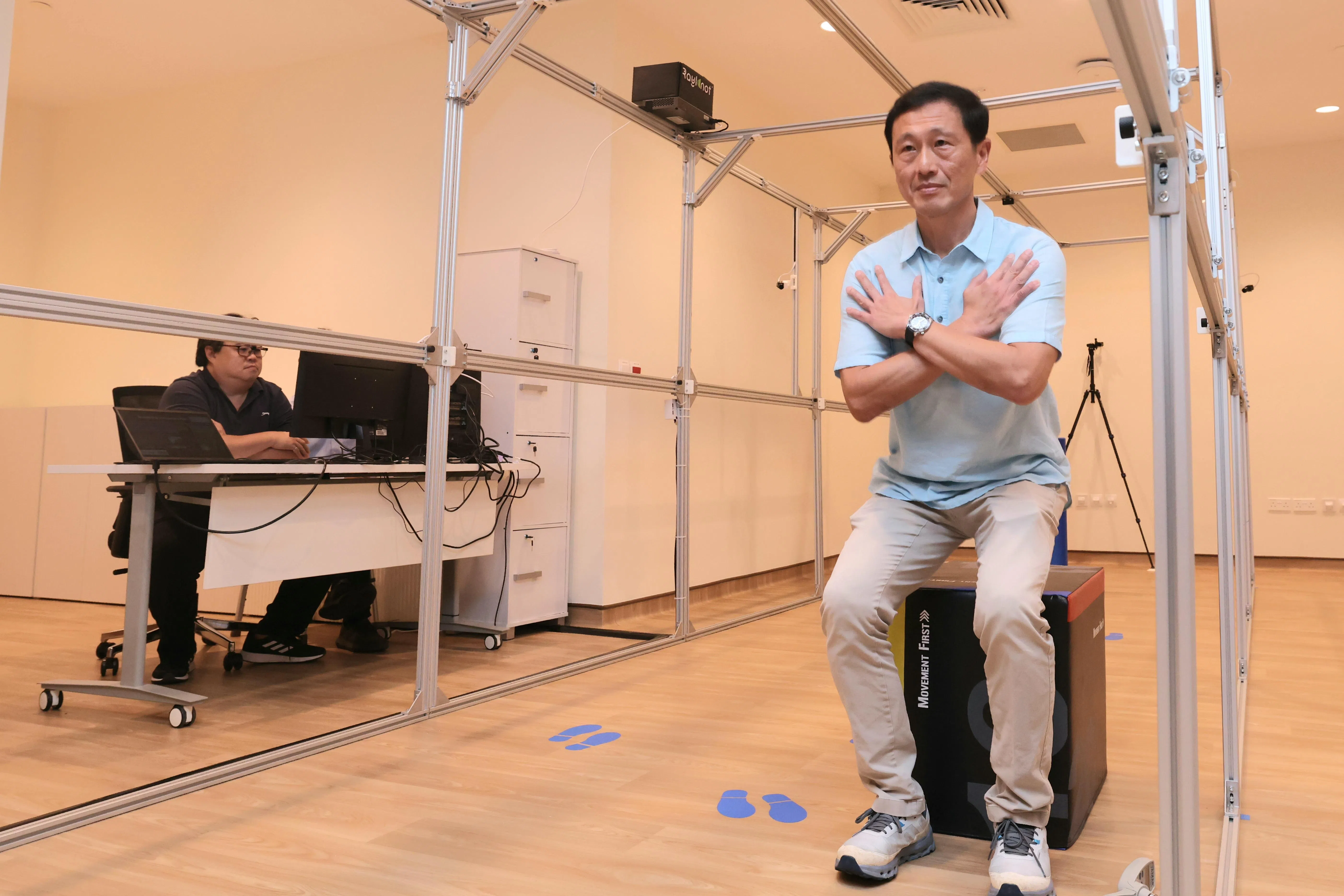 社会政策统筹部长兼卫生部长王乙康在这个安装有八个摄像头的检测走道系统中完成行走、坐下、起立等动作。（郑一鸣摄）