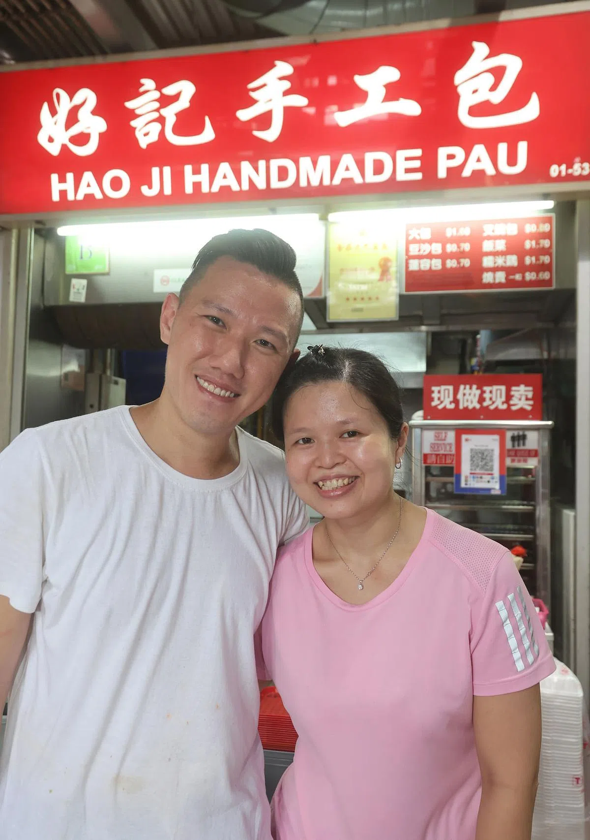 洪慧珊（右）和丈夫周宏育传承了父亲的手工包手艺，11年前在裕廊西开设好记手工包分店。（唐家鸿摄）