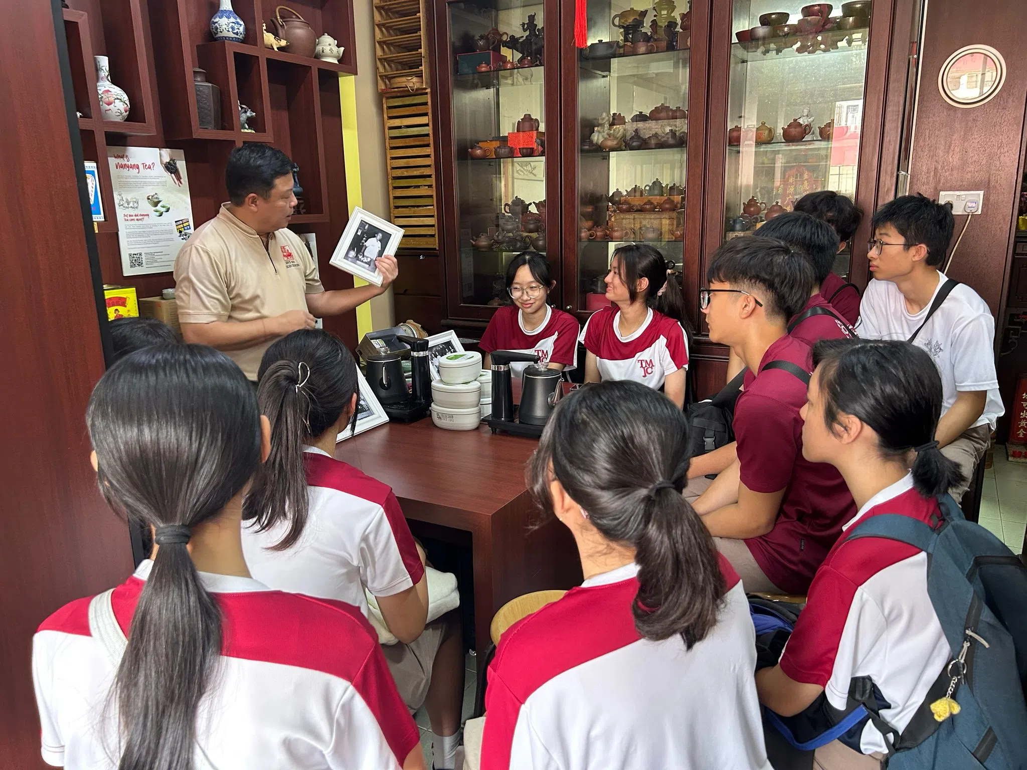 白进火在白新春茶庄为学生讲述茶庄的历史。（联合学生通讯员摄影施策摄）