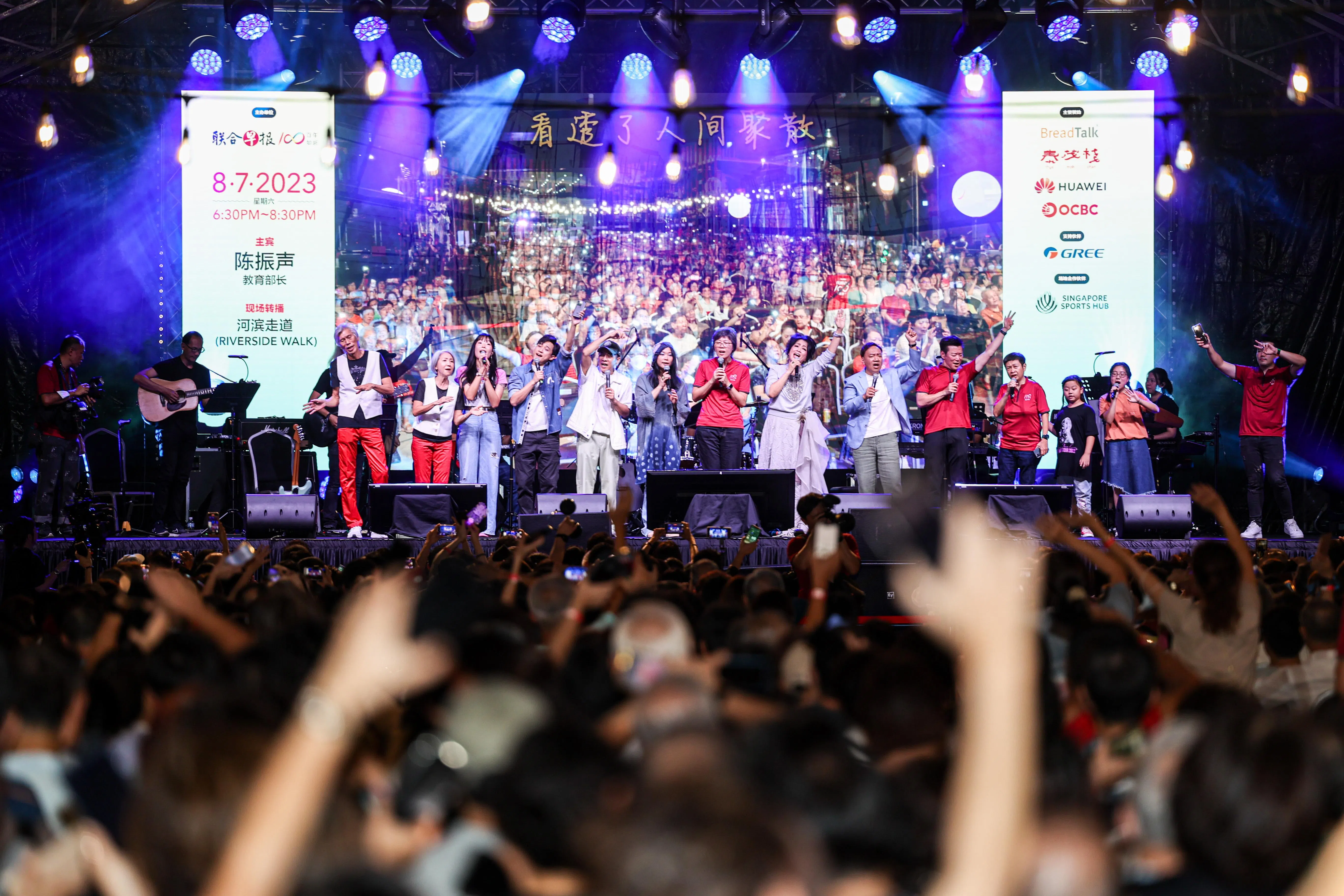 参与演出的歌手与《联合早报》的代表在演唱会首日与1200名观众温馨齐唱《城里的月光》。（关俊威摄）