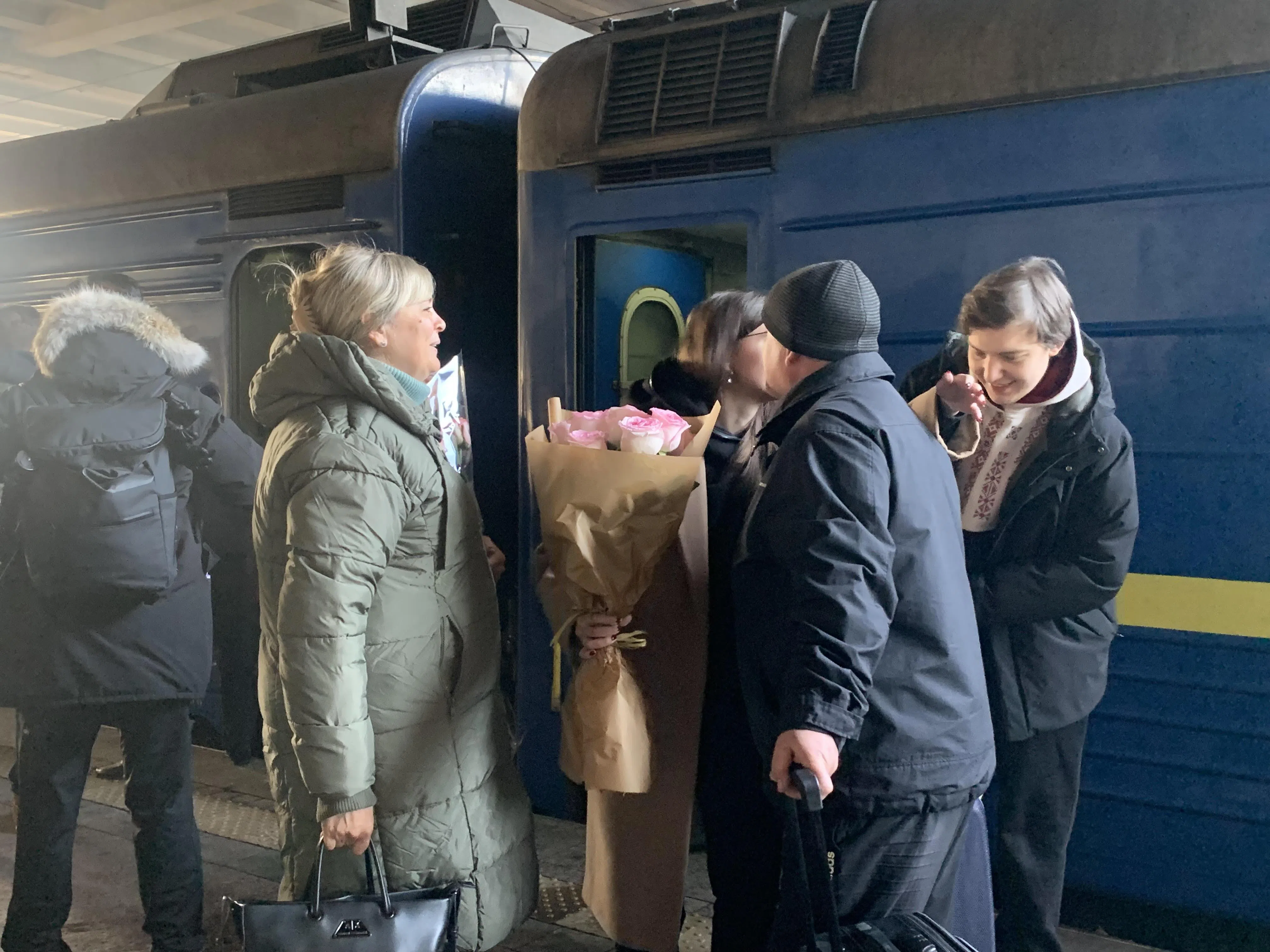 2023年11月25日，从波兰海乌姆开往乌克兰基辅的火车抵达基辅火车总站，乘客下车后与亲友拥抱。（沈泽玮摄）