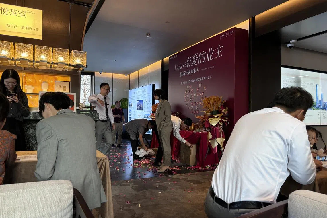 上海宝山区一个新盘售楼处内，每当有新房成交，新业主就会放响纸炮。工作人员星期三（10月2日）在售楼处清理纸炮留下的纸屑。（黎康摄）