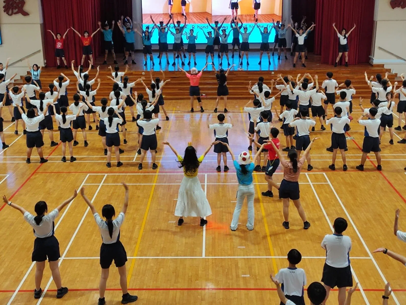 中一新生在学长姐的带领下，学习今年迎新的主题歌舞。（南侨中学学生甘佳蒽摄）