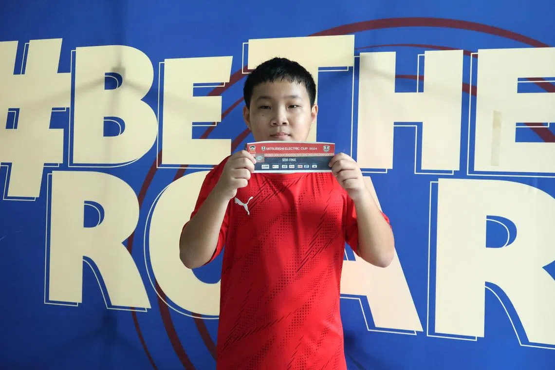 韩凌轩向记者展示他所购得的，12月26日雄狮主场对垒越南的半决赛球票。（张俊摄）