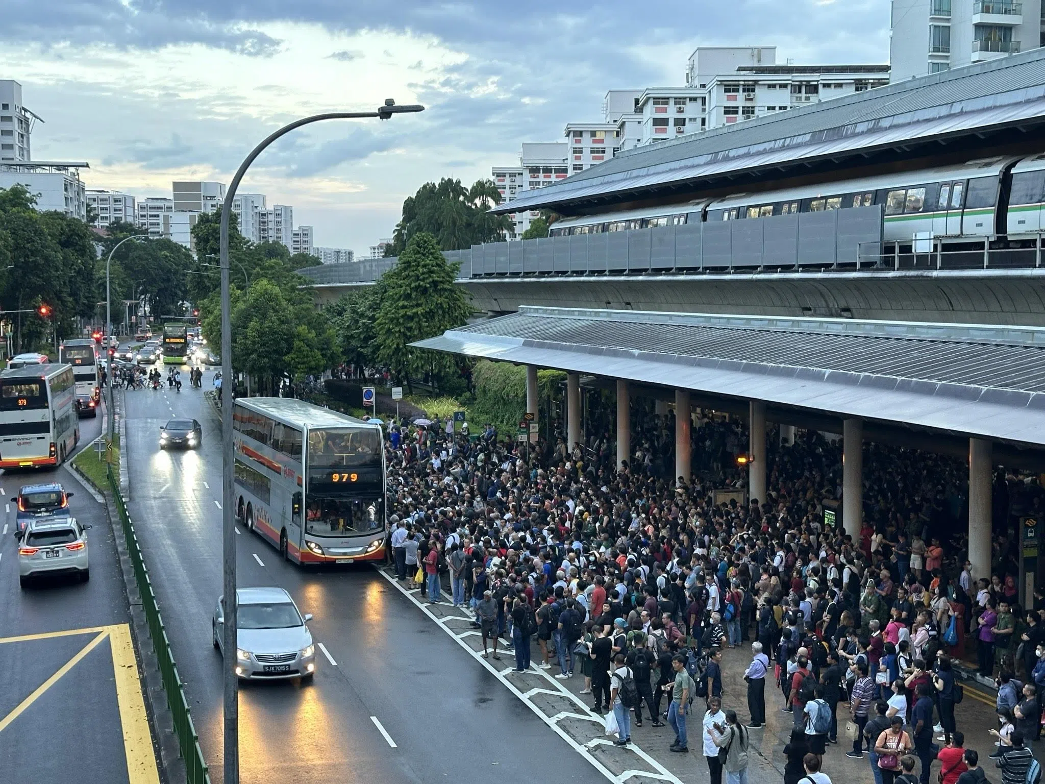 油池地铁站外等待巴士的人群涌到路中央。（安诗一摄）