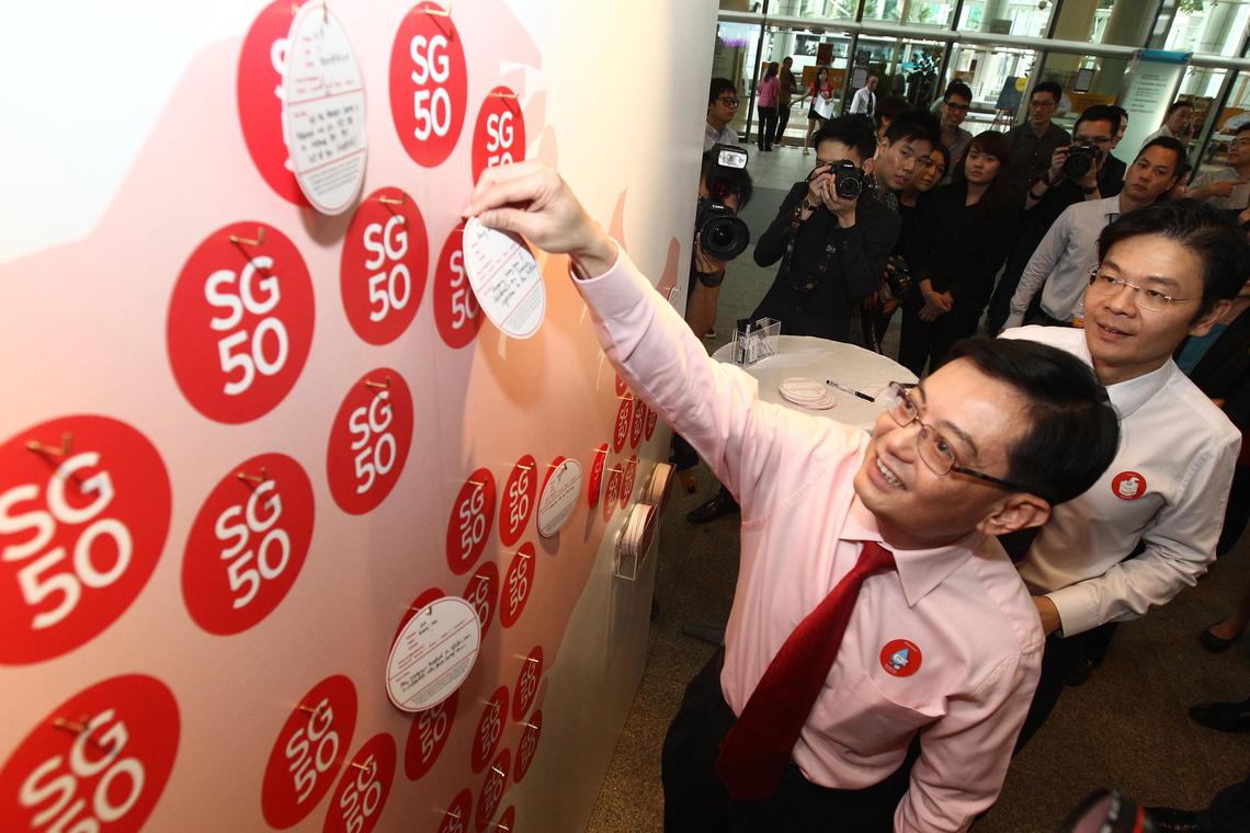 2014年1月，领导新加坡建国50周年金禧庆典指导委员会的教育部长王瑞杰（左）和时任文化、社区及青年部代部长兼通讯及新闻部高级政务部长黄循财（右），为“SG50”字样的红点标志举行推介仪式。（档案照片）