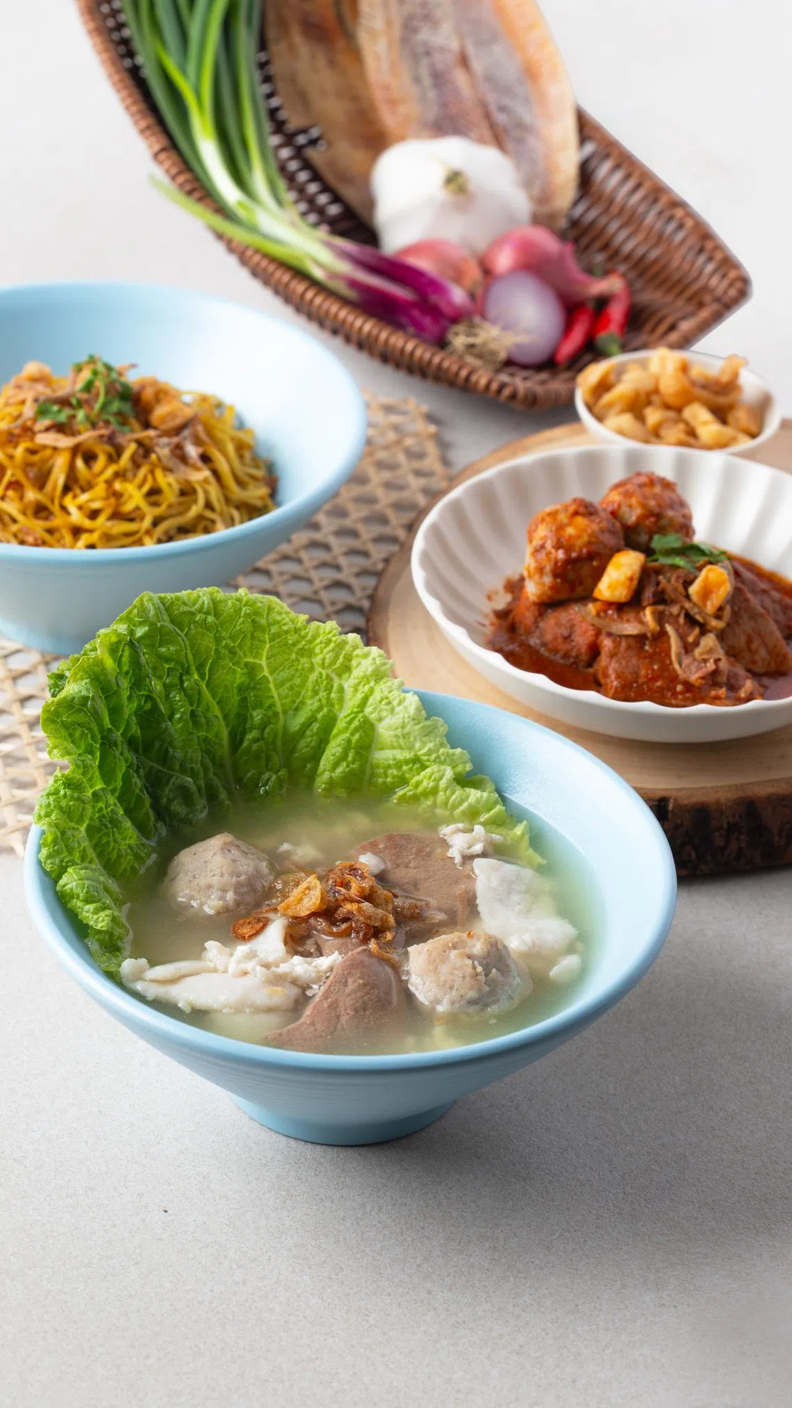 招牌肉脞面干包括一碗丰盛汤料（前）和蛋幼面，也可再点一份参峇好料（右）加料。（品牌提供）