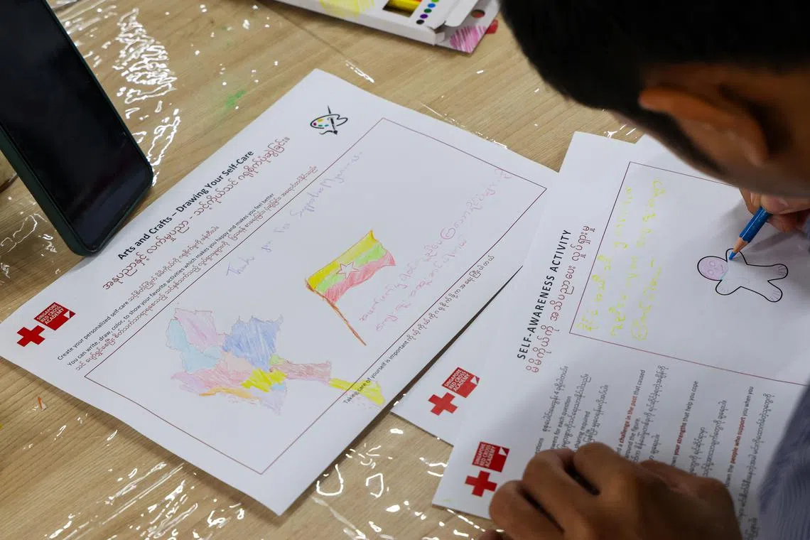 红十字会为到访者提供绘画活动，让他们抒发内心情绪。坤泰画了缅甸国旗和地图，感谢世界人民对国家的援助。（林明顺摄）