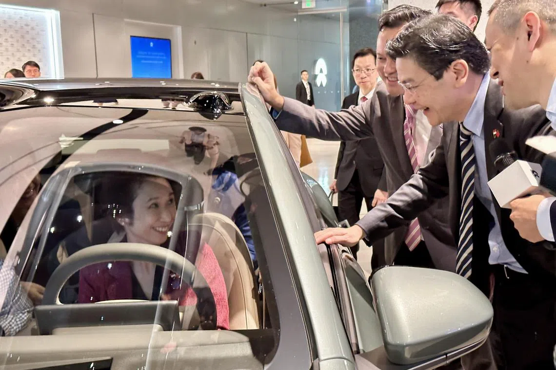 新加坡副总理兼财政部长黄循财（右二）参访中国电动车企业蔚来时，和贸工部兼文化、社区及青年部政务部长刘燕玲（左一）交流试乘感受。（陈婧摄）